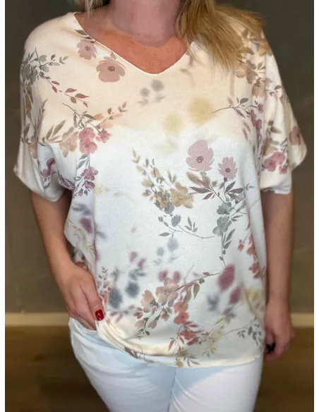 Nærbillede af det delikate blomsterprint i rosa og beige nuancer på den fine strik