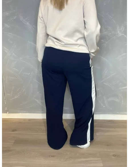 Navy blå jogging bukser med hvide sidestriber fra TIPPY, vist på model med hvid sweatshirt. vist bagfra