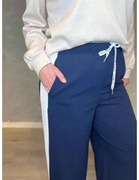 Nærbillede af elastisk linning med snøre og sidestriber
Detalje af bukser med kontrasterende hvide striber