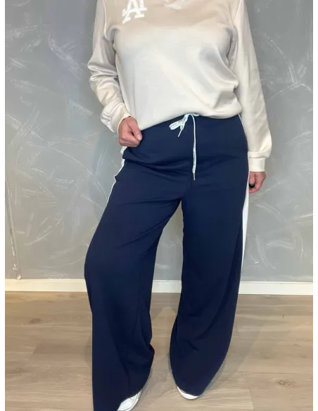 Navy blå jogging bukser med hvide sidestriber fra TIPPY, vist på model med hvid sweatshirt