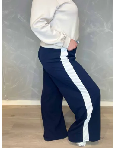 Navy blå jogging bukser med hvide sidestriber fra TIPPY, vist på model med hvid sweatshirt. vist fra siden