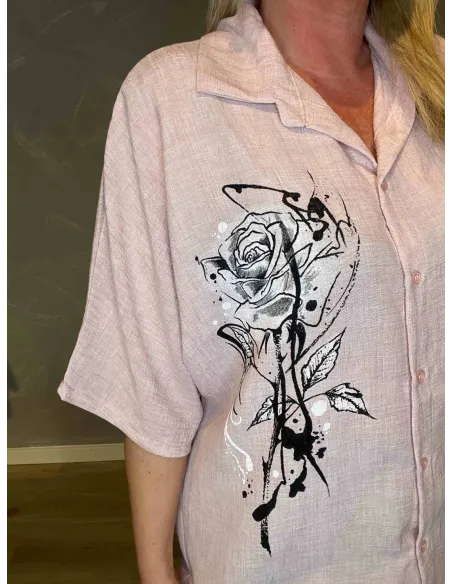 Nærbillede af det grafiske rose-print i sort og hvid på rosa skjorte