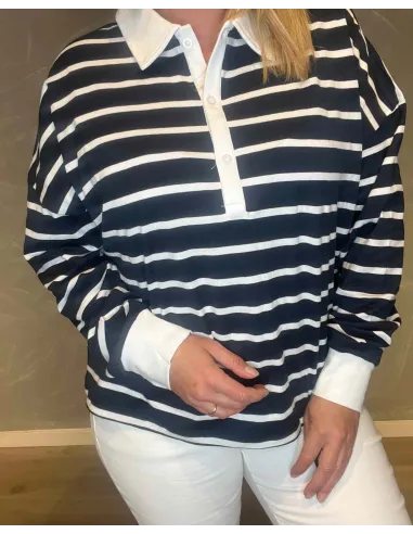 Nærbillede af den stribede kvalitet og den hvide knaplukning på polo blusen
