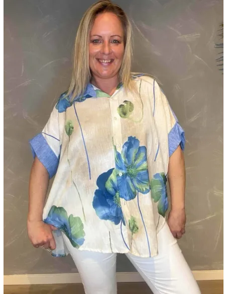 Oversize skjorte i aqua med store blå blomster, viser den afslappede pasform og opsmøgede ærmer"