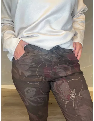 Nærbillede af blomsterprint og guld detaljer på brun strækbukser til kvinder - TIPPY"