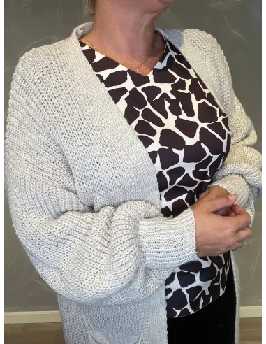 "Nærbillede af lomme detaljer på lang creme farvet cardigan"
