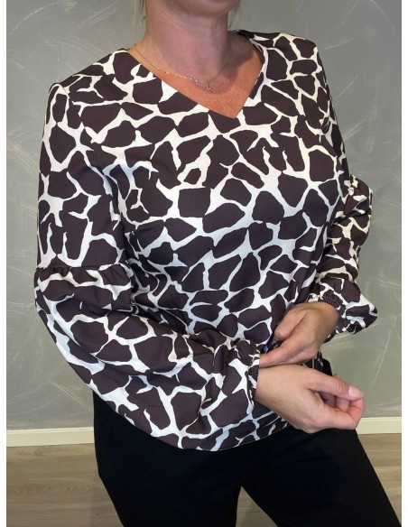 "Nærbillede af giraffe print detaljer på bluse"