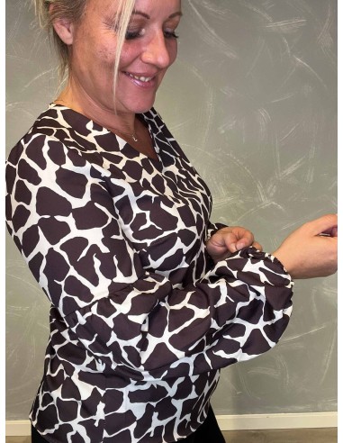 "Nærbillede af giraffe print detaljer på bluse"
