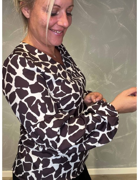 "Nærbillede af giraffe print detaljer på bluse"