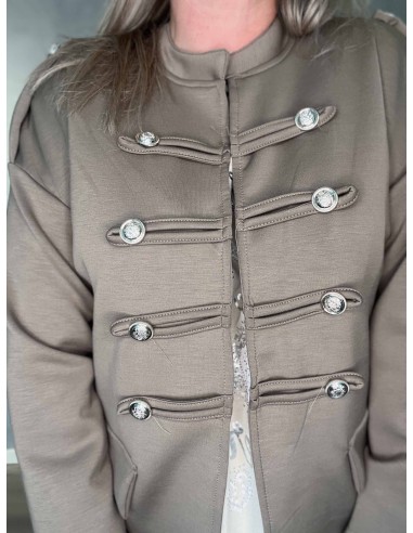 Nærbillede af pynteknapper på beige uniformsjakke – TIPPY