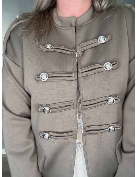 Nærbillede af pynteknapper på beige uniformsjakke – TIPPY