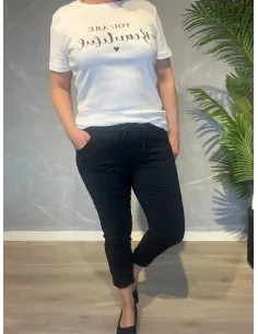 Sorte bukser fra TIPPY, vist på model med hvid t-shirt
Nærbillede af den bløde kvalitet og snøredetalje