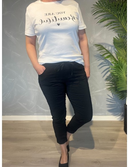 Sorte bukser fra TIPPY, vist på model med hvid t-shirt
Nærbillede af den bløde kvalitet og snøredetalje