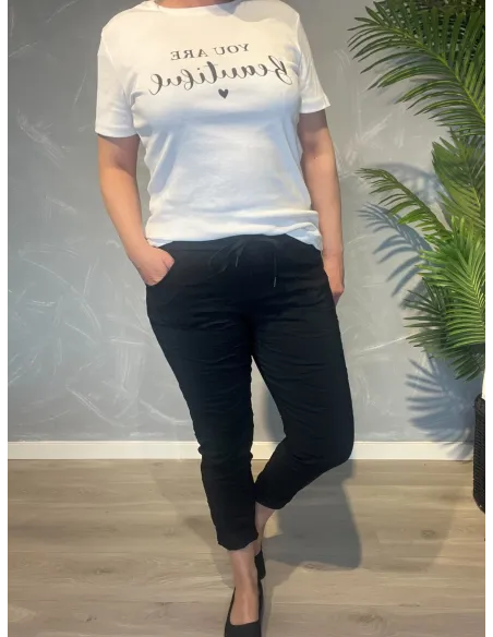 Sorte bukser fra TIPPY, vist på model med hvid t-shirt
Nærbillede af den bløde kvalitet og snøredetalje