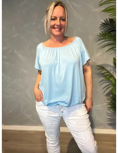 Lyseblå t-shirt med elastikkant i bund og hals, løs pasform og blødt fald,