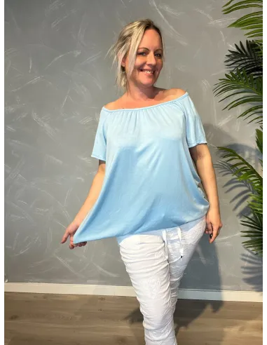 Lyseblå t-shirt med elastikkant i bund og hals, løs pasform og blødt fald, vist med udstrækket elastik