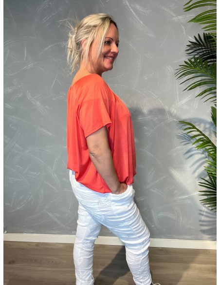 Coral t-shirt med elastikkant i bund og hals, løs pasform og blødt fald, vist på model fra siden - TIPPY