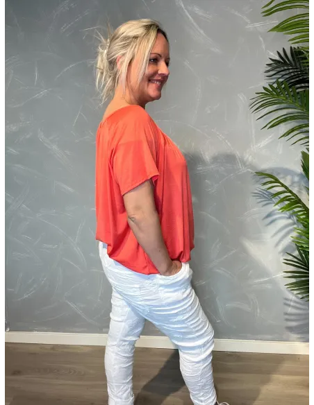 Coral t-shirt med elastikkant i bund og hals, løs pasform og blødt fald, vist på model fra siden - TIPPY