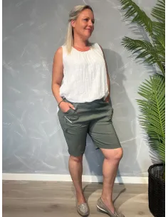 Cherry Berry shorts i khaki grøn vist på model med hvid top. Shortsene har elastik i taljen,