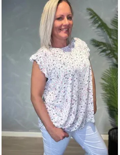 Hvid blomstret bluse med feminine flæseærmer, strækbar kvalitet og romantisk design, ses fra siden