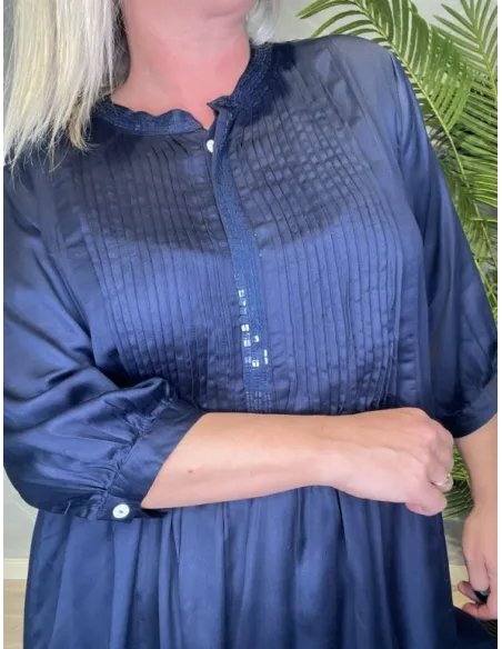 "Nærbillede af palietter langs hals og knapstolpe samt lægsygninger på brystpartiet"