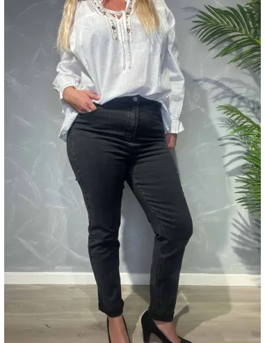 Sort slim fit jeans vist forfra på model mod grå baggrund med palmeblade