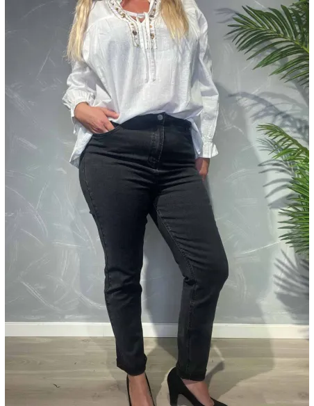 Sort slim fit jeans vist forfra på model mod grå baggrund med palmeblade