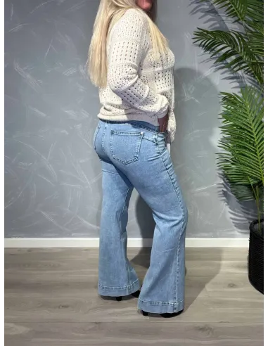 Lyse flared leg jeans fra Karostar vist bagfra på model mod grå baggrund -TIPPY
