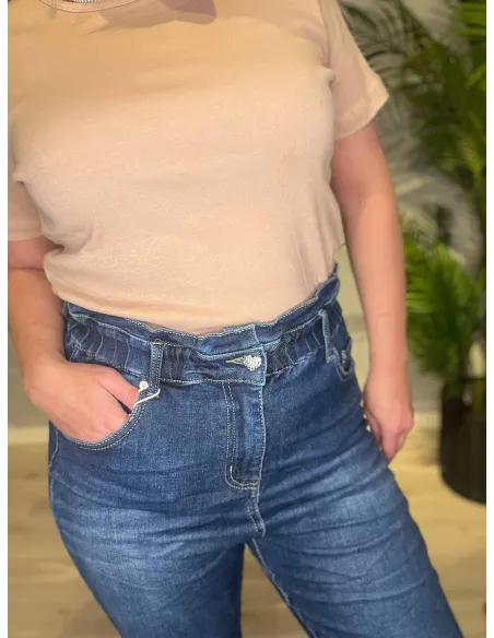 Blå højtaljede Karostar jeans stylet med beige jakke og sorte stiletter, set tæt på for detaljer af lommer og lukning -TIPPY