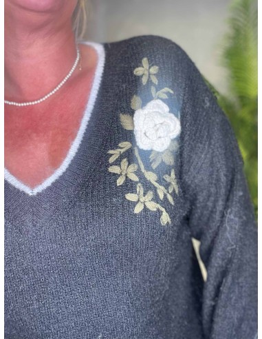 close up af Sort strik med hvide kanter og broderet blomster