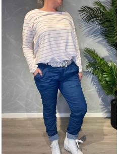 Jeans-farvede bukser med stræk fra TIPPY, vist på model med stribet top og sølvbælte