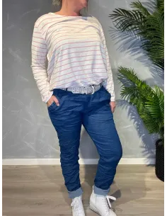 Jeans-farvede bukser med stræk fra TIPPY, vist på model med stribet top og sølvbælte