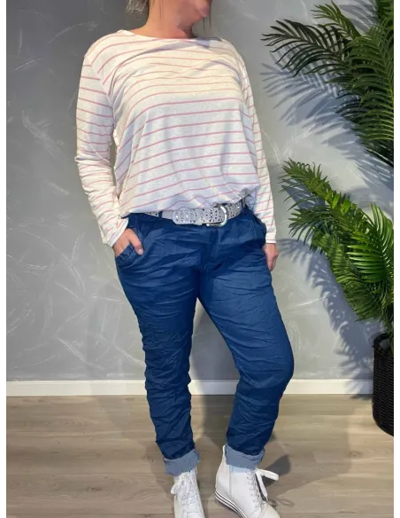 Jeans-farvede bukser med stræk fra TIPPY, vist på model med stribet top og sølvbælte