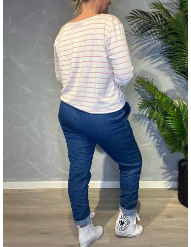 Jeans-farvede bukser med stræk fra TIPPY, vist på model med stribet top og sølvbælte, vist bagfra