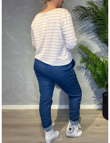 Jeans-farvede bukser med stræk fra TIPPY, vist på model med stribet top og sølvbælte, vist bagfra