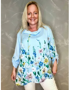 Lyseblå bluse med blomsterprint vist på model mod grå baggrund