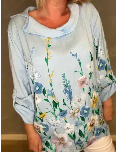 Lyseblå bluse med blomsterprint vist på model mod grå baggrund 2
