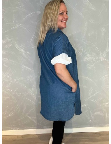 Bagside af den lange denimskjorte, viser det flotte fald og den feminine silhuet, med bluse inden under