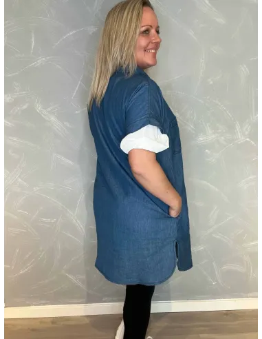 Bagside af den lange denimskjorte, viser det flotte fald og den feminine silhuet, med bluse inden under